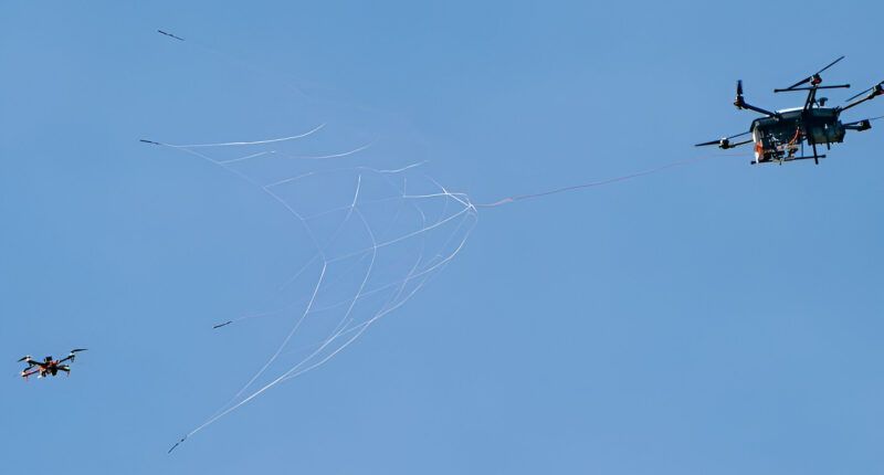 US interceptor drone with net-gun can defend infrastructure from UAV swarm attack